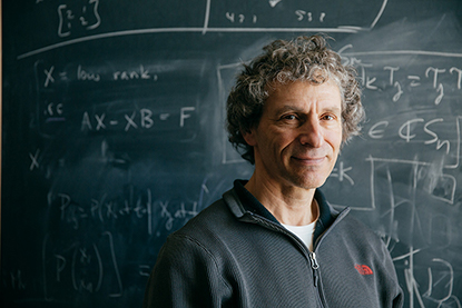 photo of Dan Rockmore in front of a blackboard